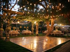 an outdoor dance with lights strung from the ceiling and tables set up for a party