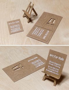 two different business cards sitting on top of a wooden table next to an easel