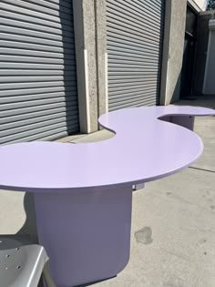 two purple tables sitting next to each other on the side of a building with shutters