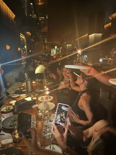 a group of people sitting at a table with food and drinks in front of them