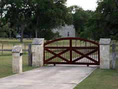 a gated driveway leading to a stone house