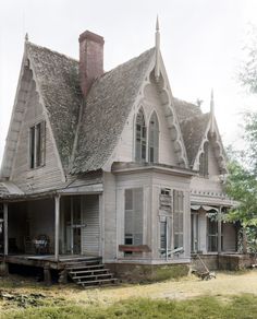 an old house with a thatched roof and two porches is shown in black and white