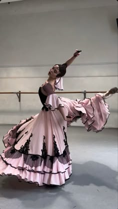 a woman in a pink dress is dancing