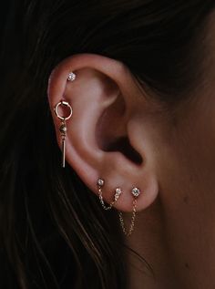 a close up of a person with ear piercings on their ears and behind the ear