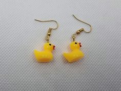 two yellow rubber ducks are hanging from gold earwires