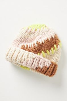 a knitted hat with multicolored details on the brim and sides, sitting on a white surface