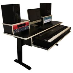 a computer desk with two keyboards and speakers