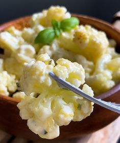 a wooden bowl filled with macaroni and cheese