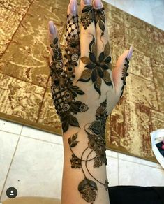 a woman's hand with henna tattoos on it