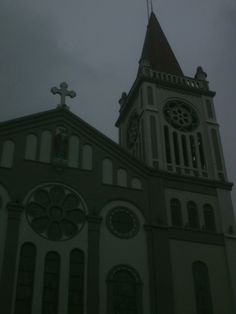 an old church with a steeple and cross on top