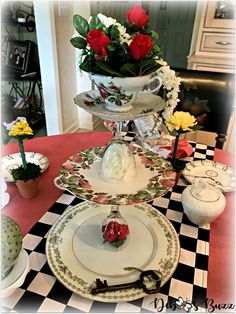 three tiered plates with flowers in them on a table