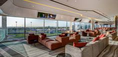 an airport lounge area with seating and large windows looking out onto the tarmacs