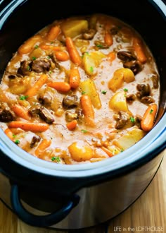 a crock pot filled with beef and potatoes