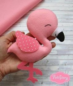 a hand holding a pink stuffed animal with polka dots on it's breast and legs