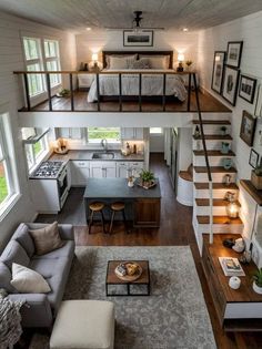 a living room and kitchen with stairs leading to the upper floor, above which is a loft bed