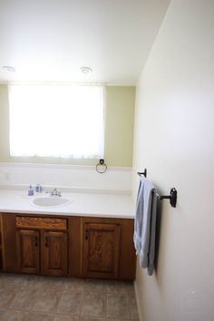 a bathroom with a sink, mirror and towel rack on the wall next to it