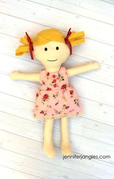 a doll with blonde hair wearing a pink dress and holding her arms in the air