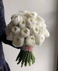 a woman holding a bouquet of white roses