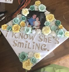 a graduation cap decorated with flowers and the words, i know she's smiling