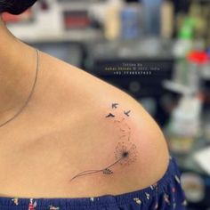 a woman with a dandelion tattoo on her left shoulder and the back of her stomach