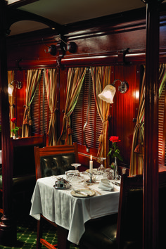 a dining car on a train with tables and chairs set up for two people to eat