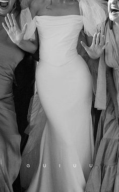 three women dressed in white posing for the camera with one holding her arms out and smiling