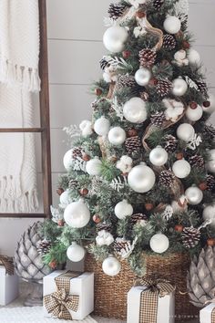 a christmas tree with white and silver ornaments