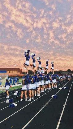 a group of cheerleaders standing on top of a track