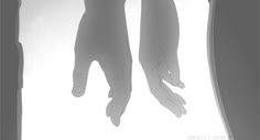 two hands reaching towards each other in front of a window