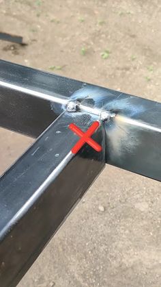 a close up of a metal rail with a red cross on the top and bottom