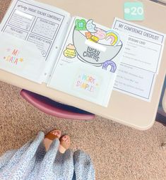 a person laying on the floor with their feet up in front of an open book