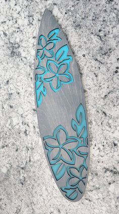 a wooden surfboard with blue flowers on it