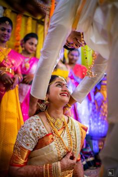 the bride and groom are getting ready for their hindu wedding ceremony in this candid photo