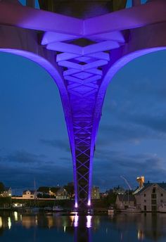 an illuminated walkway over water at night