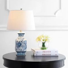 a lamp sitting on top of a table next to two books