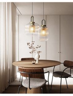 a dining room table with three lights hanging from the ceiling