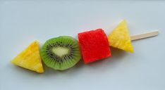 fruit skewers are arranged in the shape of an apple, kiwi and pineapple