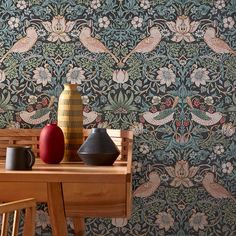 two vases are sitting on a table in front of a wallpapered background