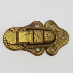 an antique brass plated metal buckle on a white background