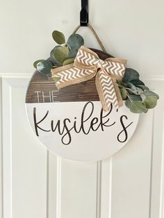 a sign hanging on the front door that says kusler's with an arrow