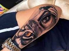 a woman's arm with a tiger tattoo on it and an orange eye in the center