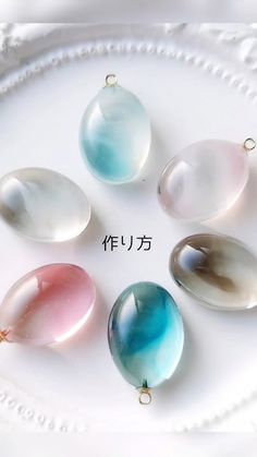 five different colored glass beads on a white plate with japanese writing in the middle and below them