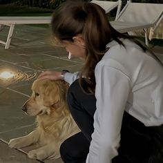 a woman kneeling down next to a dog