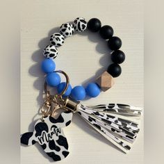 a bracelet with charms on it and a keychain that says mama in black, white, and blue