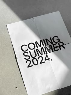 a white paper with the words coming summer 2012 on it sitting next to a skateboard