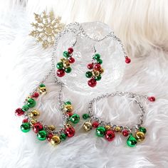 two bracelets with bells on them sitting on a white furnishing next to a snowflake