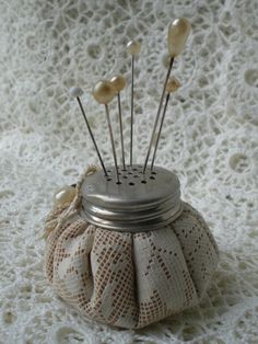 a small jar with some pins in it