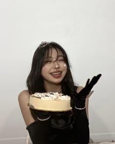 a woman sitting on the floor with a cake in front of her face and hands