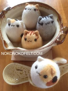 four small stuffed animals in a bowl on a table