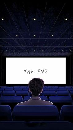 a man sitting in front of a large screen with the words the end on it